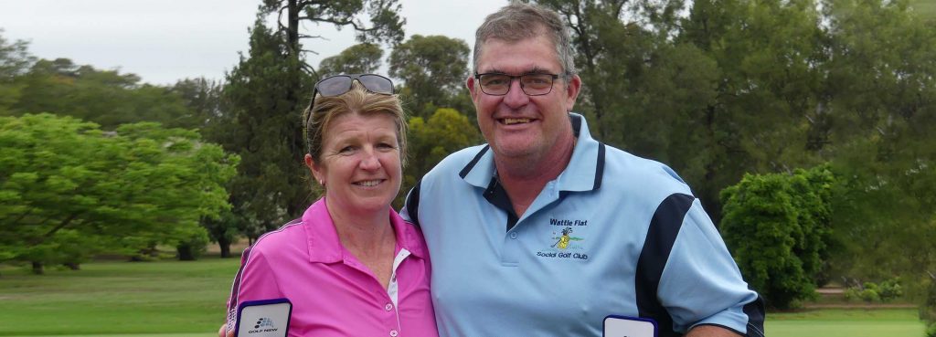 Two golfers with trophies smiling